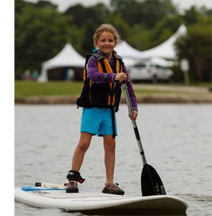 Young girl on a stand up paddleboard on the the lake at James Island County Park