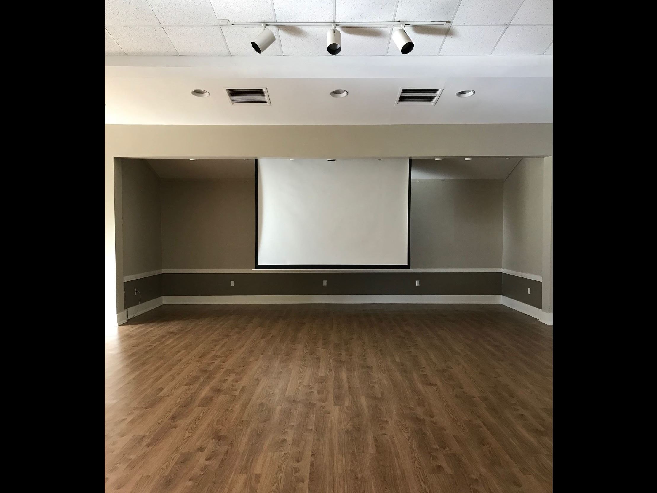 Empty hall with projection screen pulled down