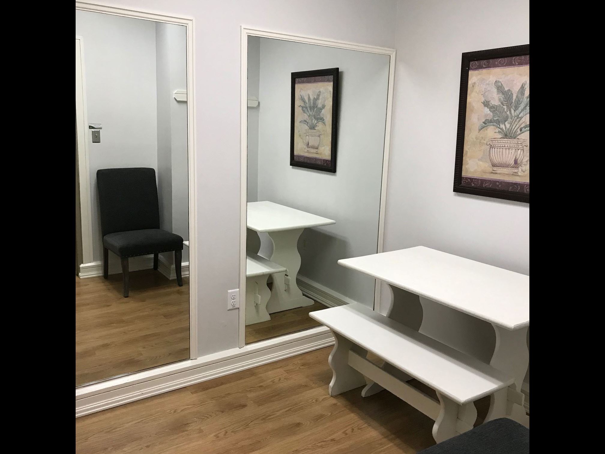 Dressing room with table, bench, and mirrors