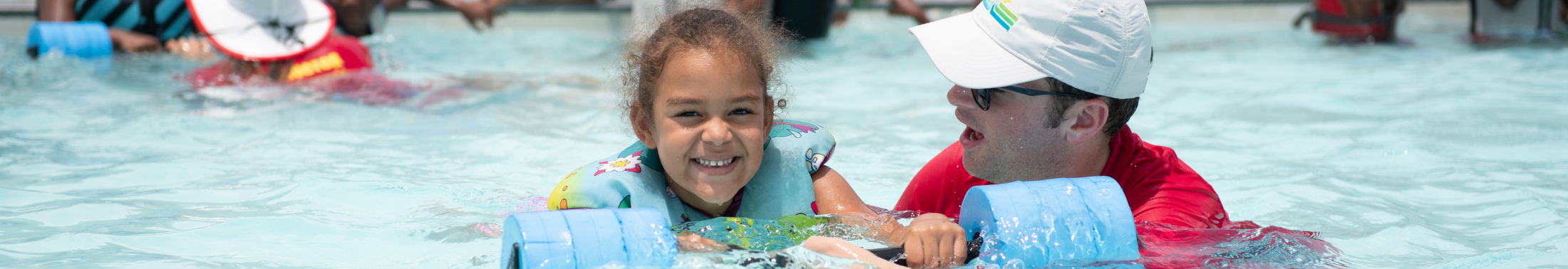 Little girl takes swim lessons with instructor