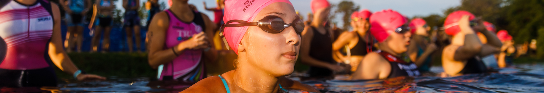 Group of girls prepare to swim a race in a lake