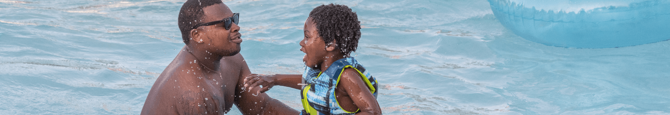 A man and a boy swim at the waterpark