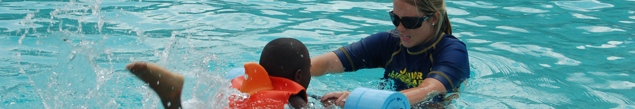 Instructor teaching a child how to swim