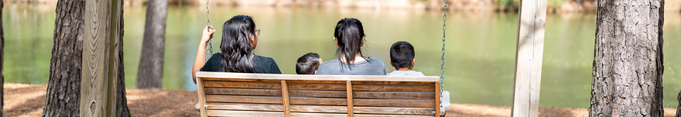 A family sitting on a bench overlooking the water
