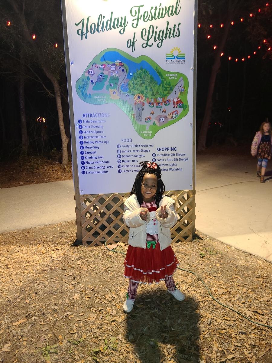 A little girl stands in front of an area map at the Holiday Festival of Lights.