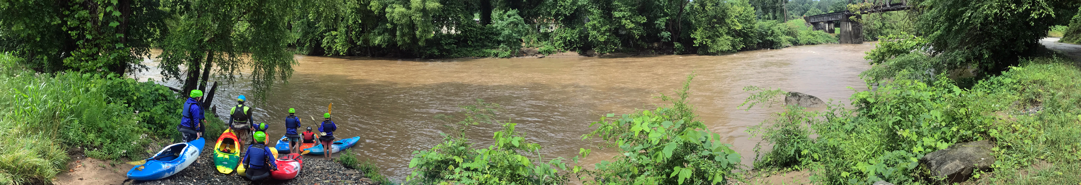Teen campers on the water in whitewater kayaks