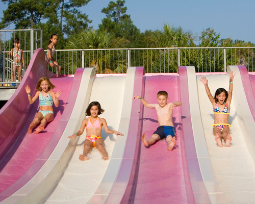 Children sliding down slides in Otter Bay