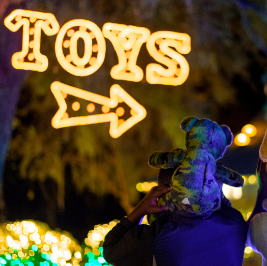 Person holding teddy bear at the Holiday Festival of Lights