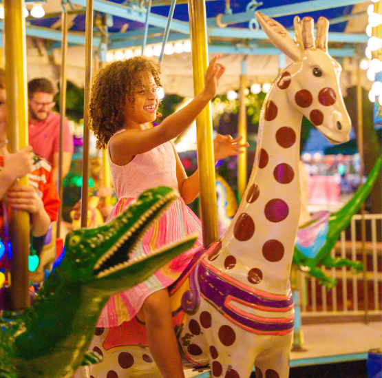 Little girl riding the carousel at the Holiday Festival of Lights.