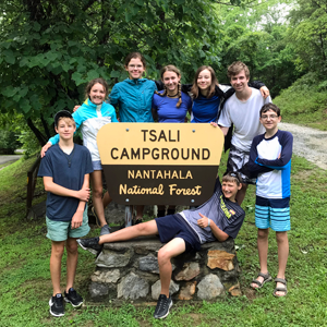 Teen campers posing around the Tsali National Recreation Area sign